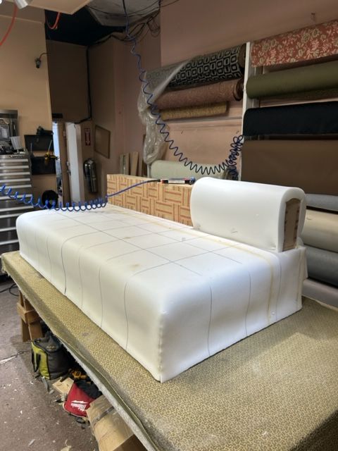 A white couch is sitting on top of a wooden table in a room.