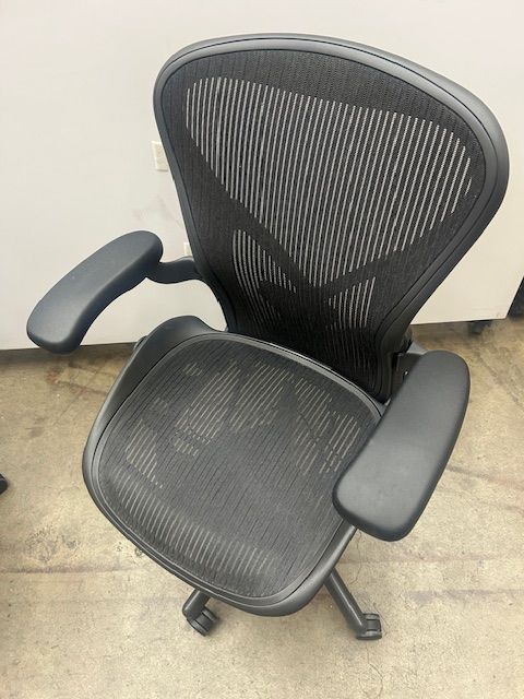 A black mesh office chair with black arm rests