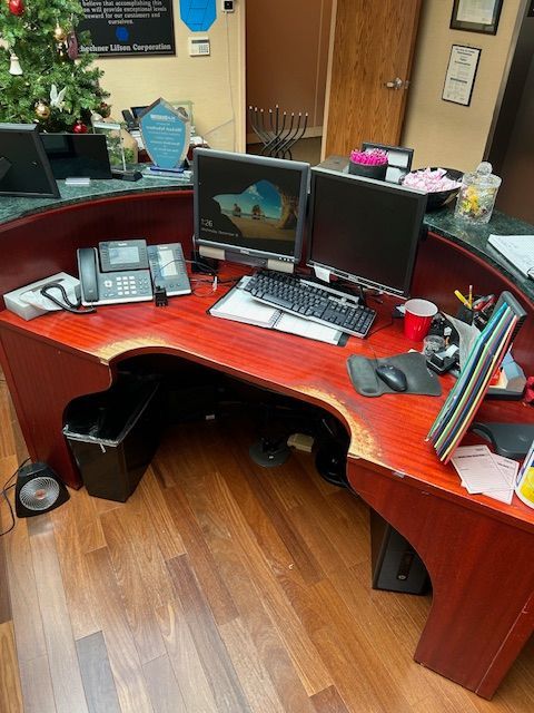 A desk with two computer monitors and a phone on it
