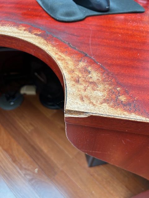 A man is cleaning a wooden table in a room