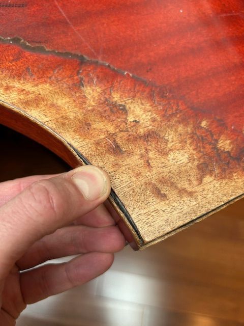 A man is cleaning a wooden table in a room