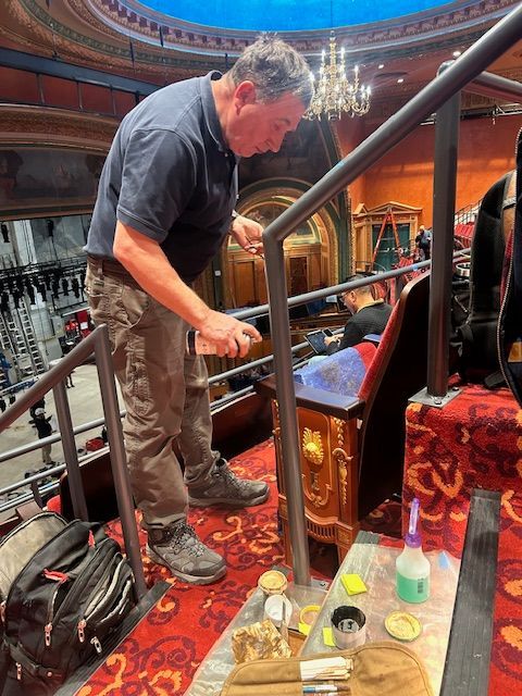 Person repairing theater chairs