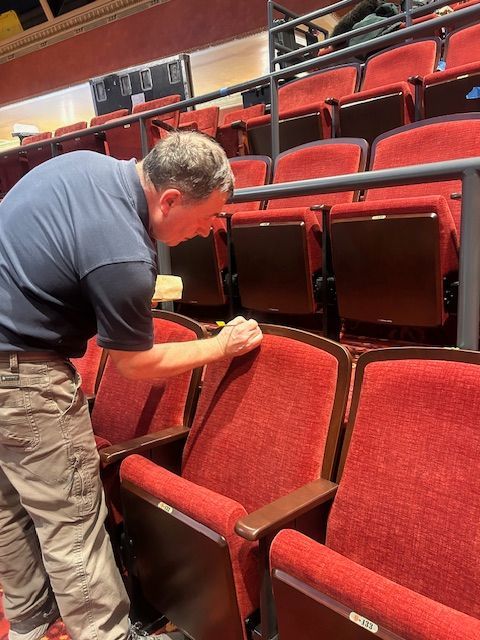 Person cleaning theater chairs