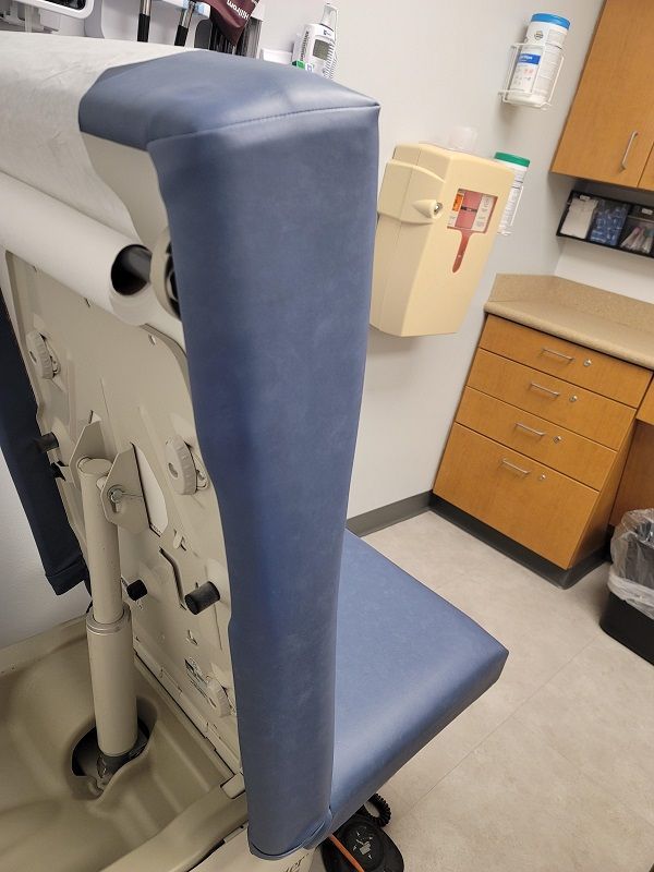 A gray couch is sitting next to a white wall.