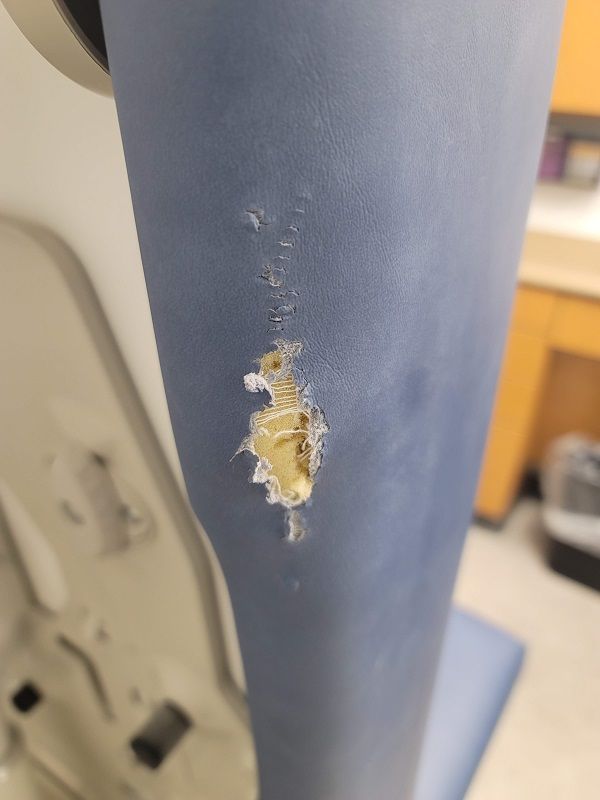 A close up of a chair with a hole in it.