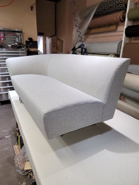 A white couch is sitting on top of a white table.