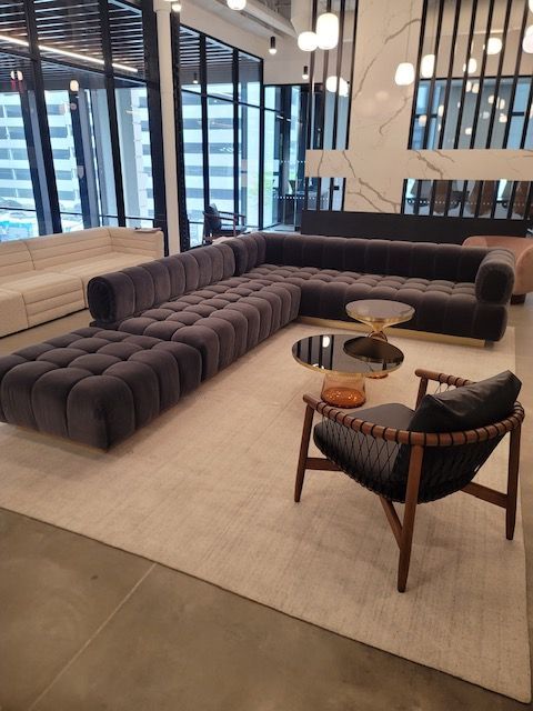 A living room with a large sectional couch and chairs