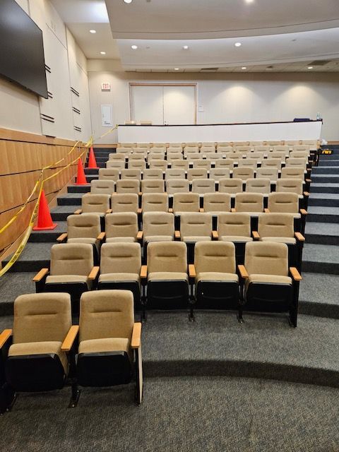 An empty auditorium with rows of chairs and stairs