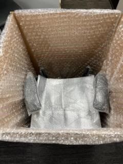 A cardboard box filled with bubble wrap and a piece of paper.