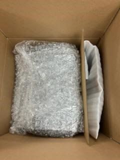 A cardboard box filled with bubble wrap and foam.