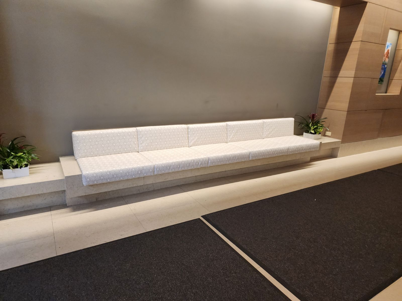 A long white couch sits in a waiting room