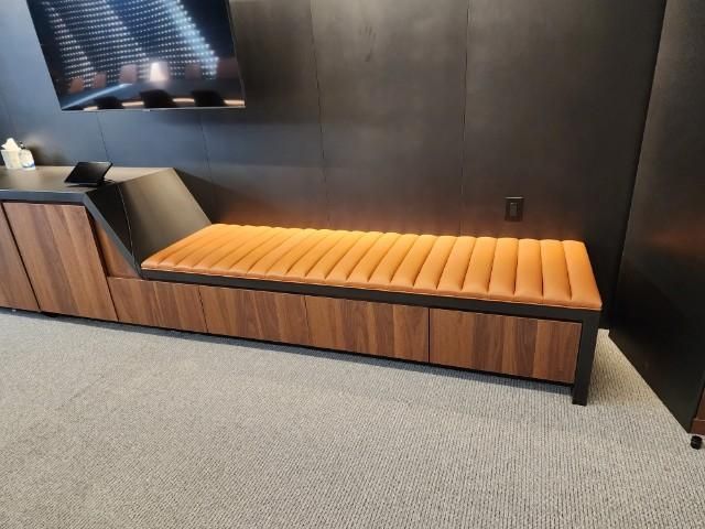 A wooden bench with a brown cushion in a room