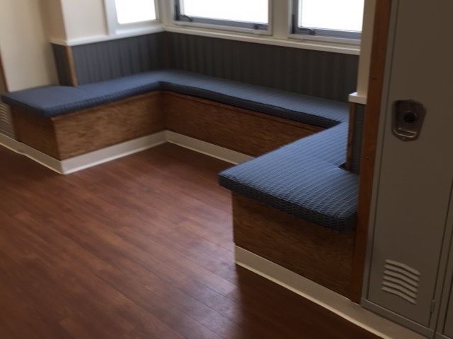 A hallway with a bench and a locker