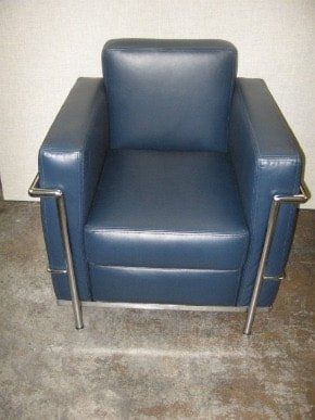 A blue leather chair is sitting on a concrete floor.