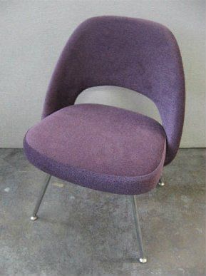A purple chair is sitting on a concrete floor