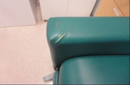 A green chair with a scratch on the arm rest