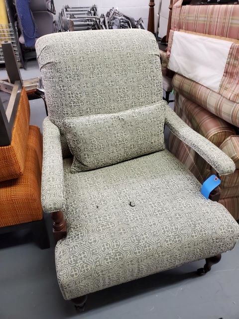 A chair with a pillow on it is sitting in a room with other chairs.