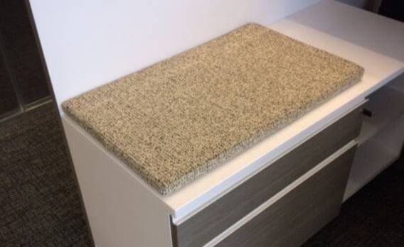 A cutting board is sitting on top of a white cabinet