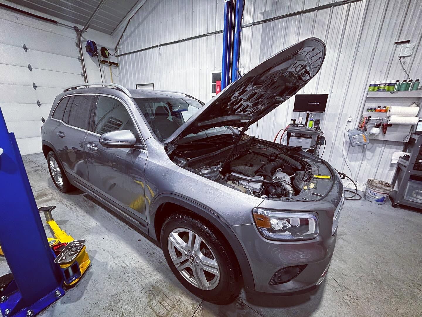 Gray SUV in a service garage with hood open for maintenance, front left view | Pommerer's Automotive