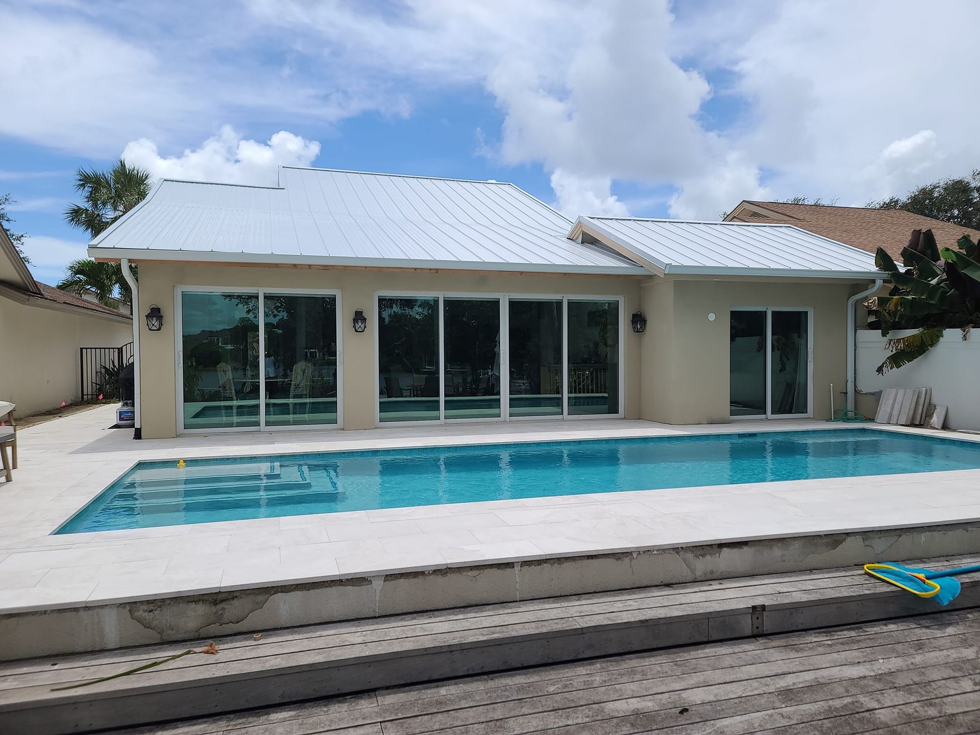 A house with a large swimming pool in front of it.
