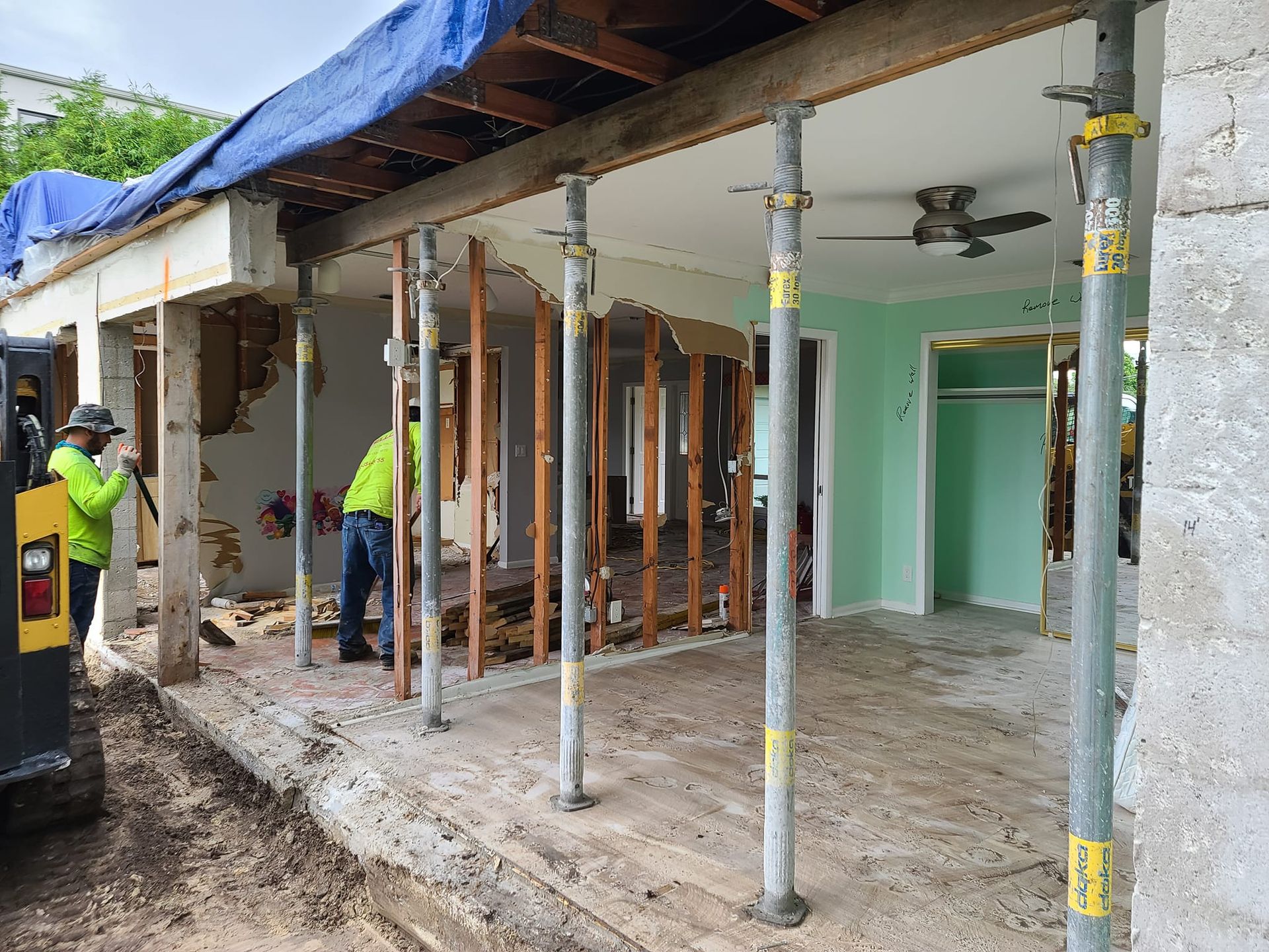 A group of construction workers are working on a house under construction.