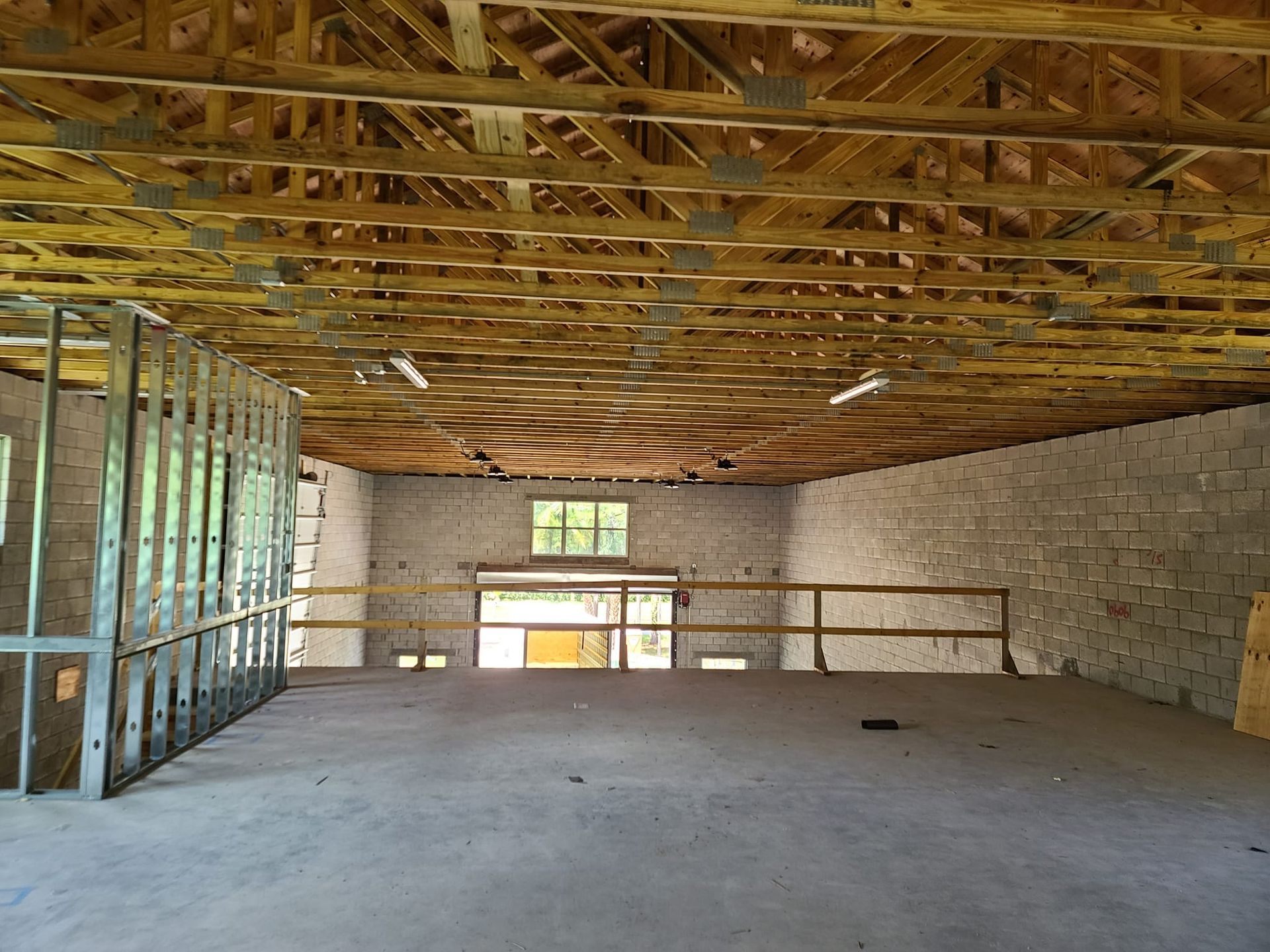 A large empty room with a wooden ceiling and brick walls.
