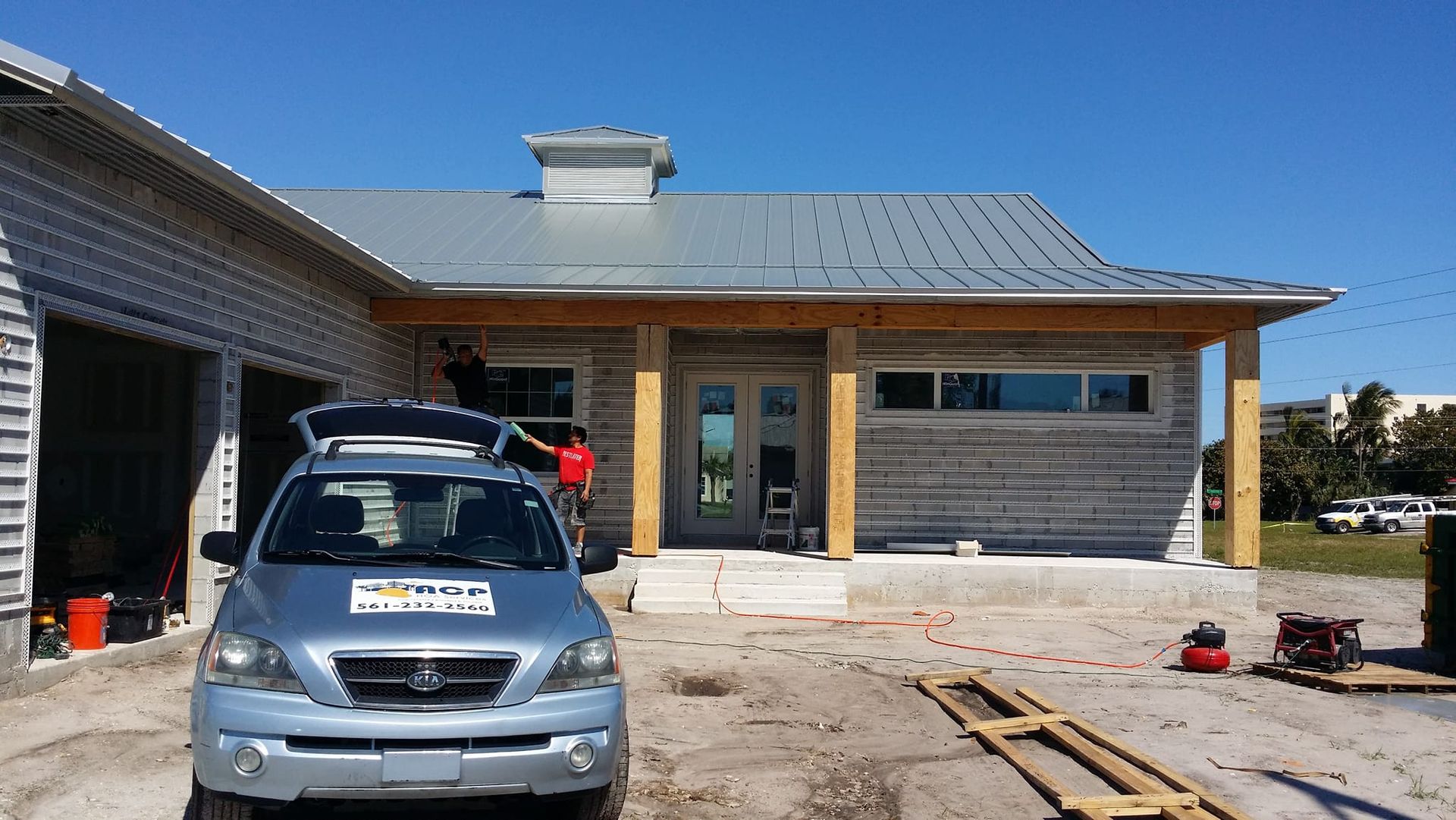 A car is parked in front of a house that is being built