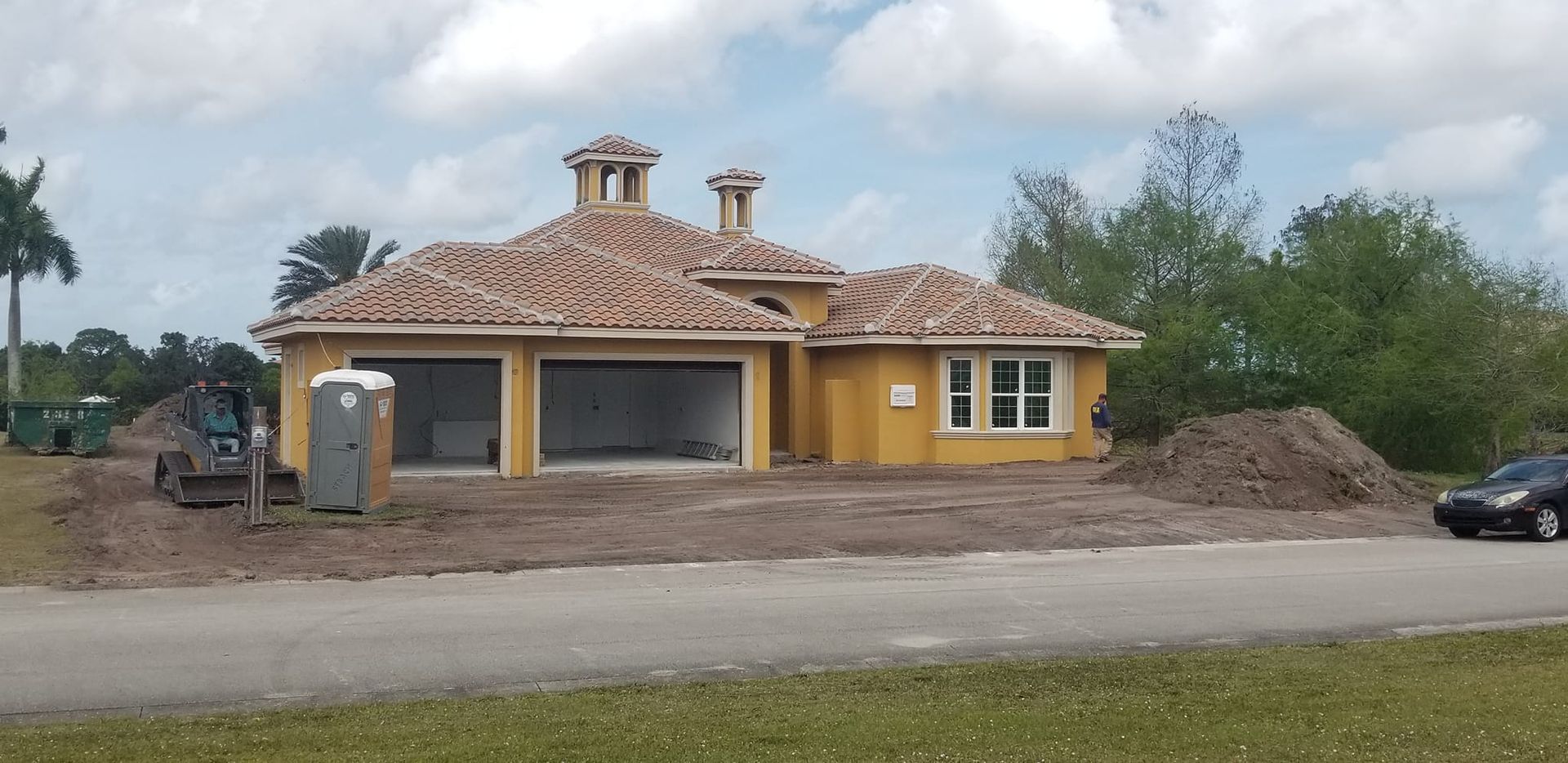 A car is parked in front of a house under construction