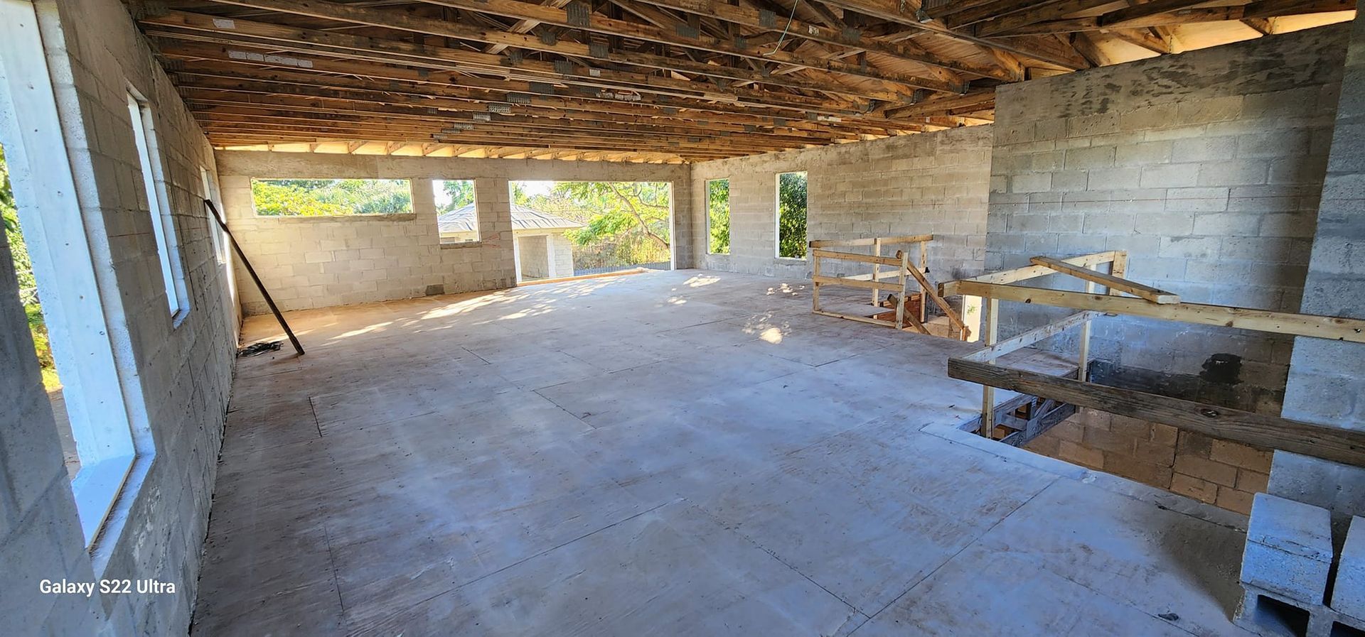 A large empty room with a wooden ceiling and a lot of windows.
