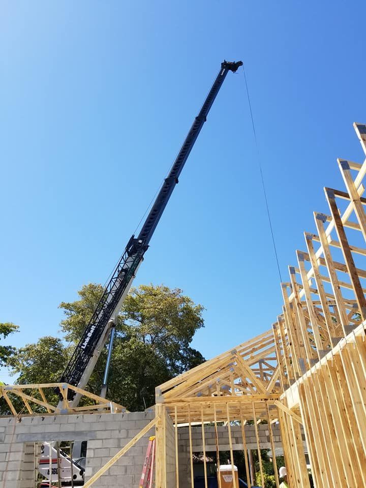 A large crane is lifting a wooden structure on a construction site.