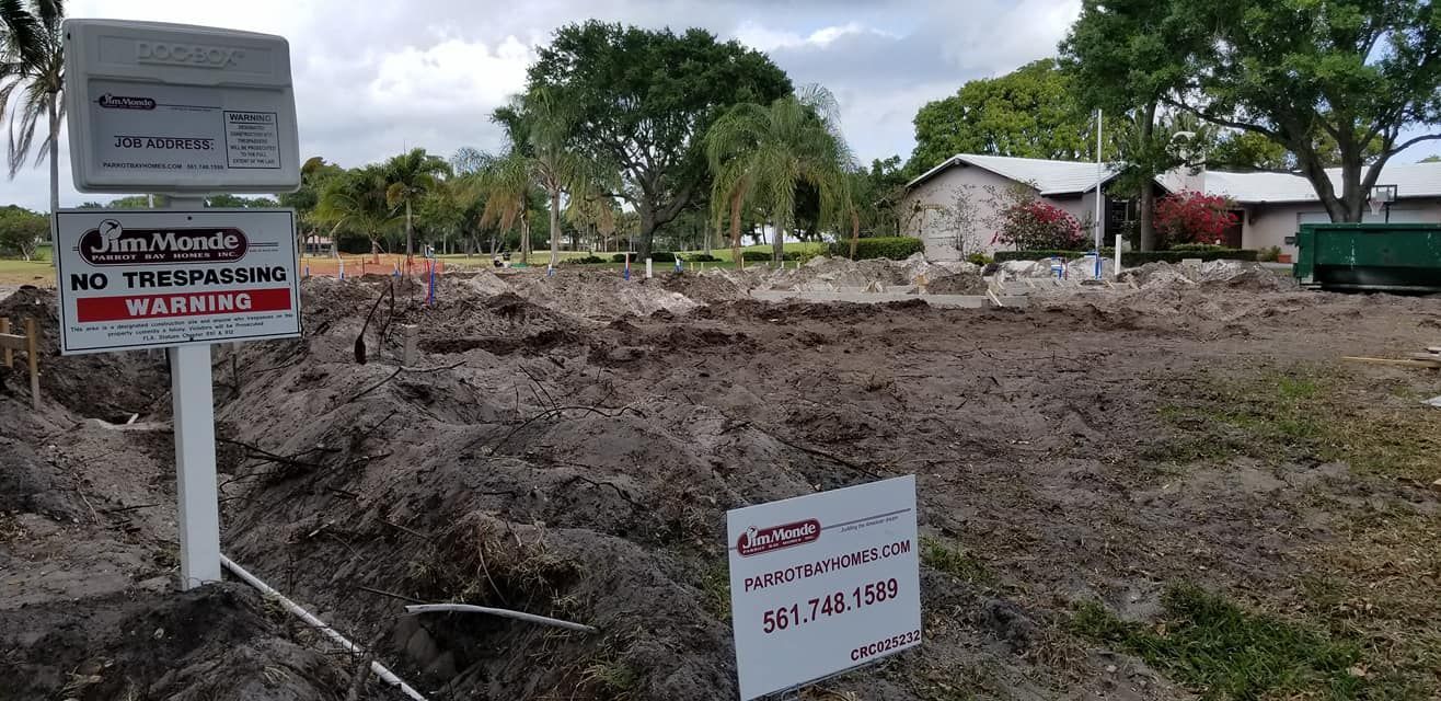 A for sale sign is sitting in the middle of a dirt field.