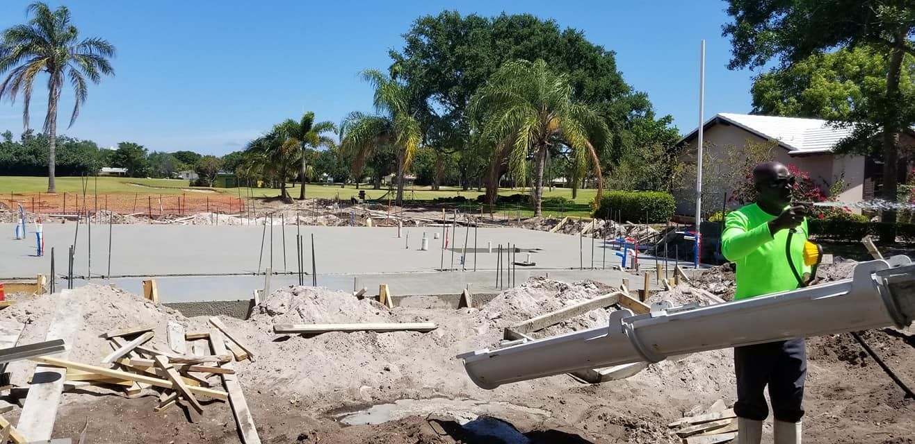 A man is standing in the dirt holding a large pipe.