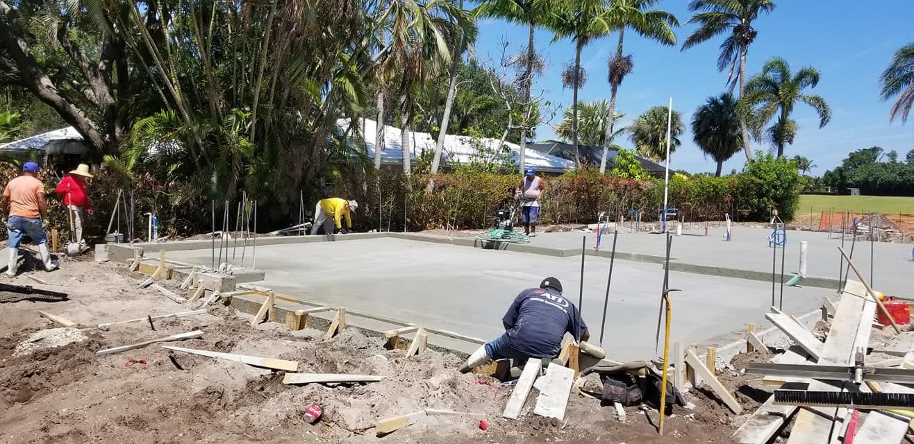 A group of construction workers are working on a concrete base.