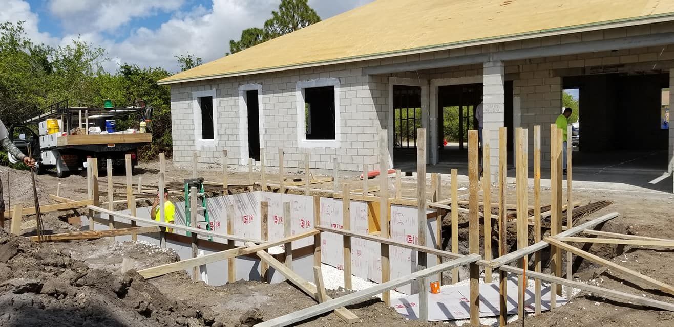 A house is being built with a pool in the backyard.
