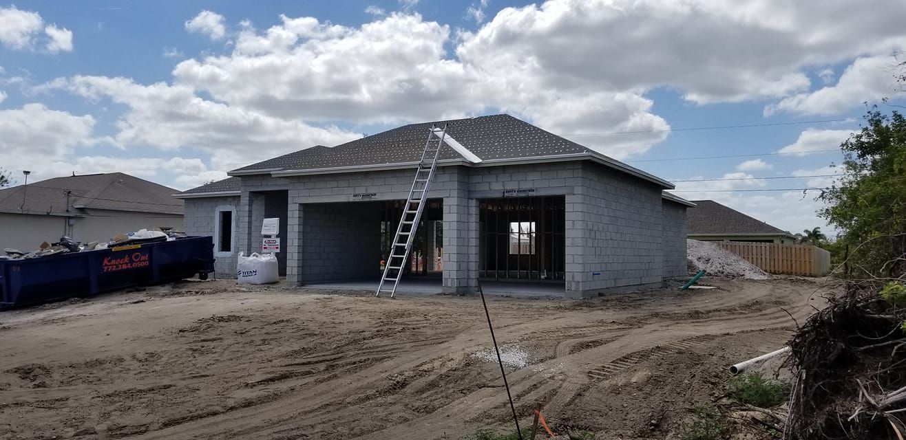 A house is being built in the middle of a dirt field.