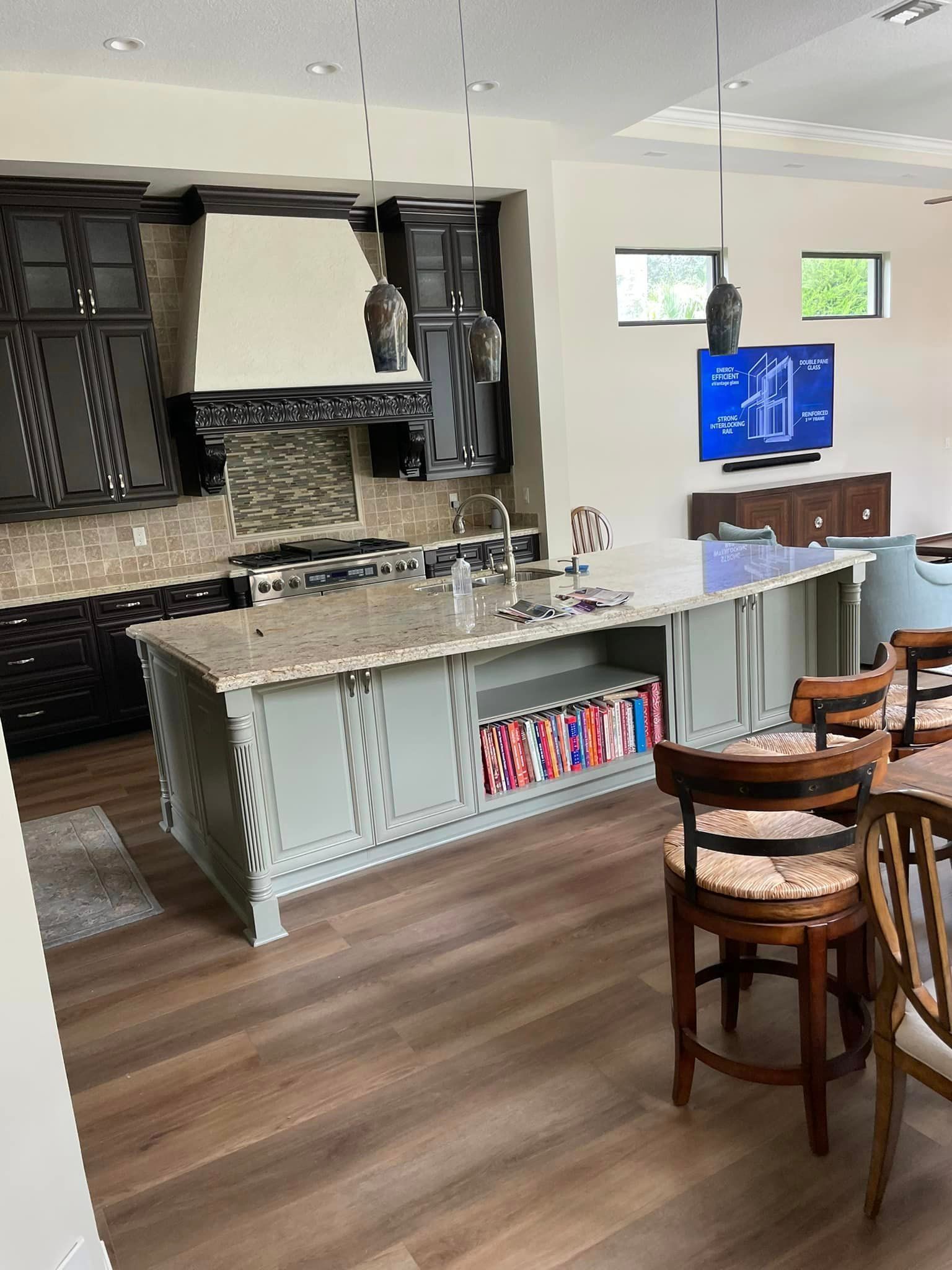 A kitchen with a large island and a television on the wall.