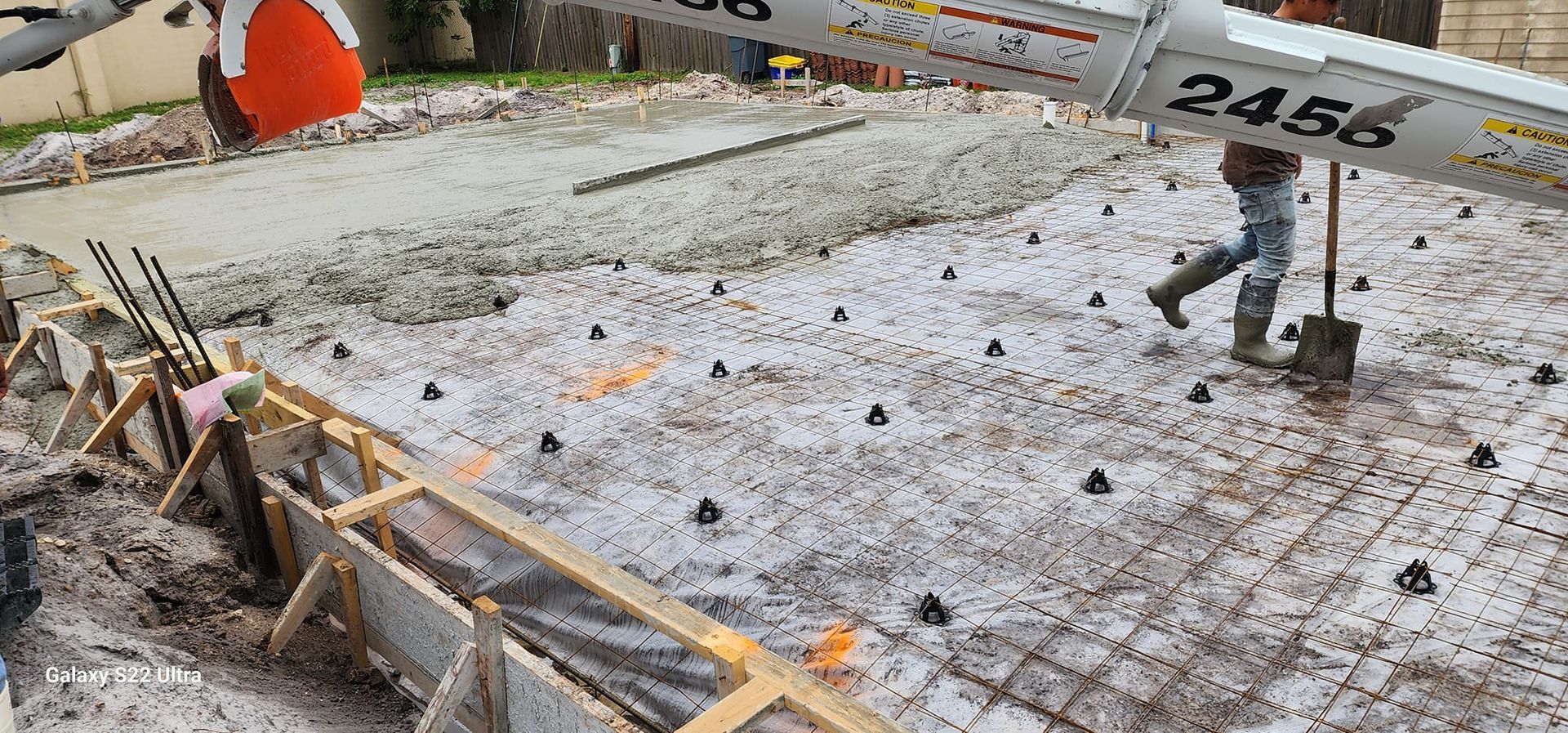 A concrete pump is being used to pour concrete into a foundation.