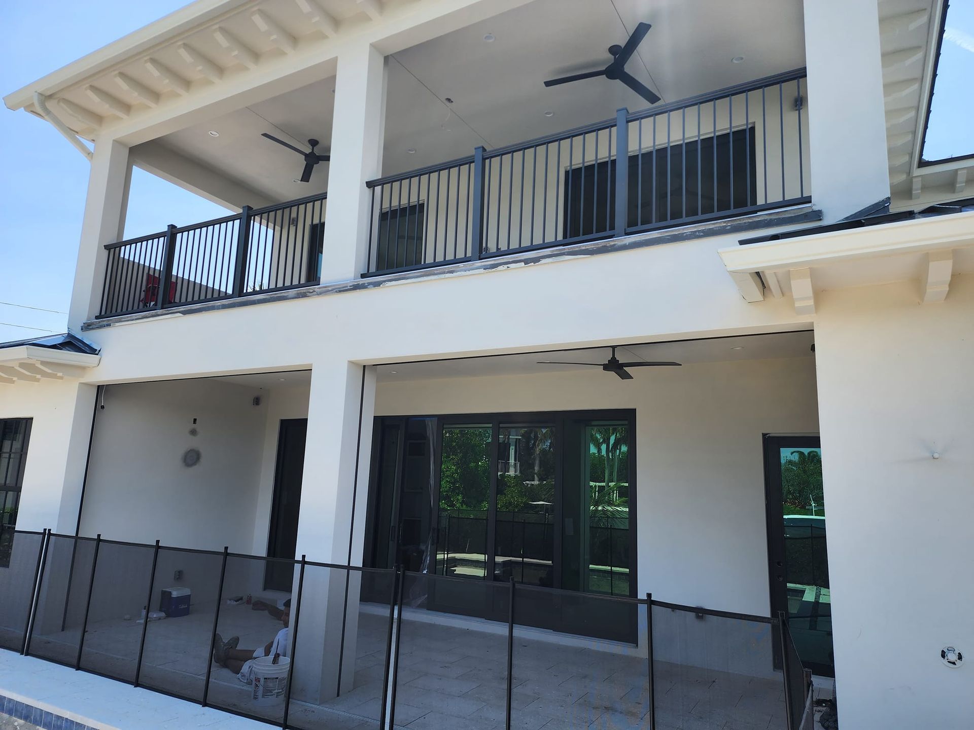 A white house with a balcony and a fence around it