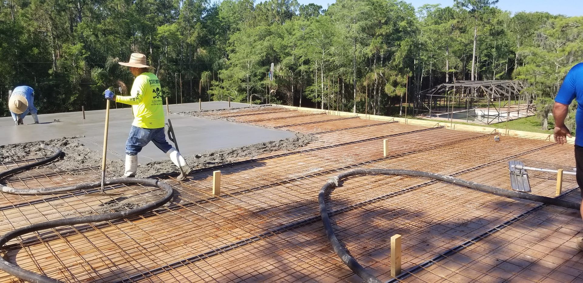 A group of construction workers are working on a concrete floor.