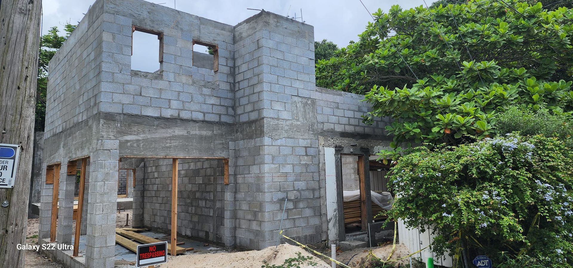 A brick house is being built in the middle of a forest.
