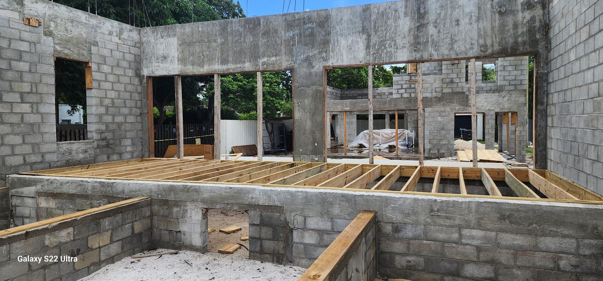 A building under construction with a lot of windows and a wooden floor.