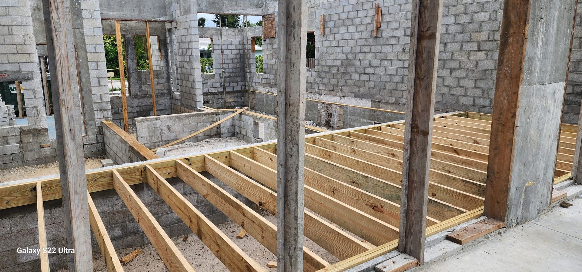 A house is being built with wooden beams and bricks.