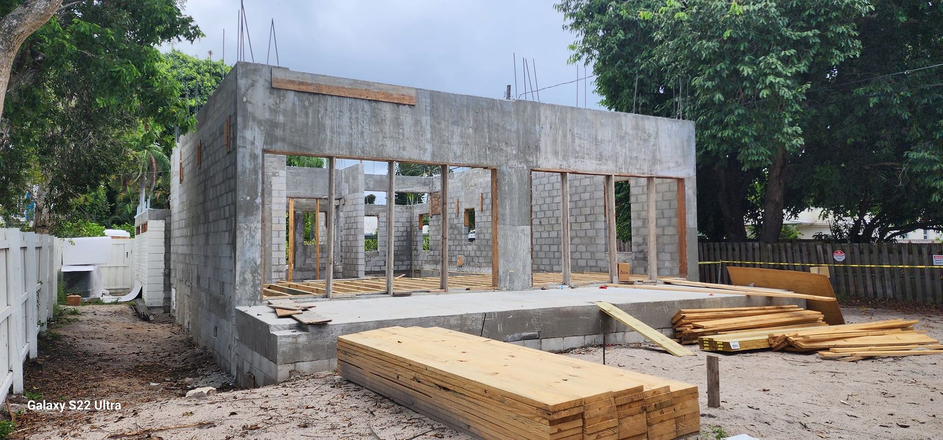 A large concrete building is being built in a backyard.