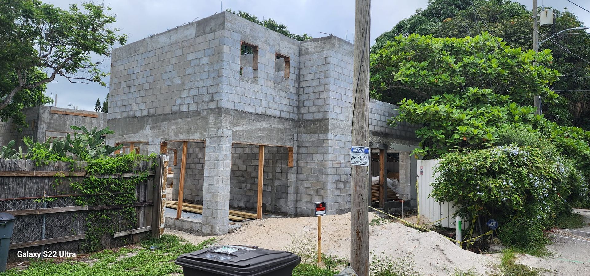 A house is being built in the middle of a lush green field.