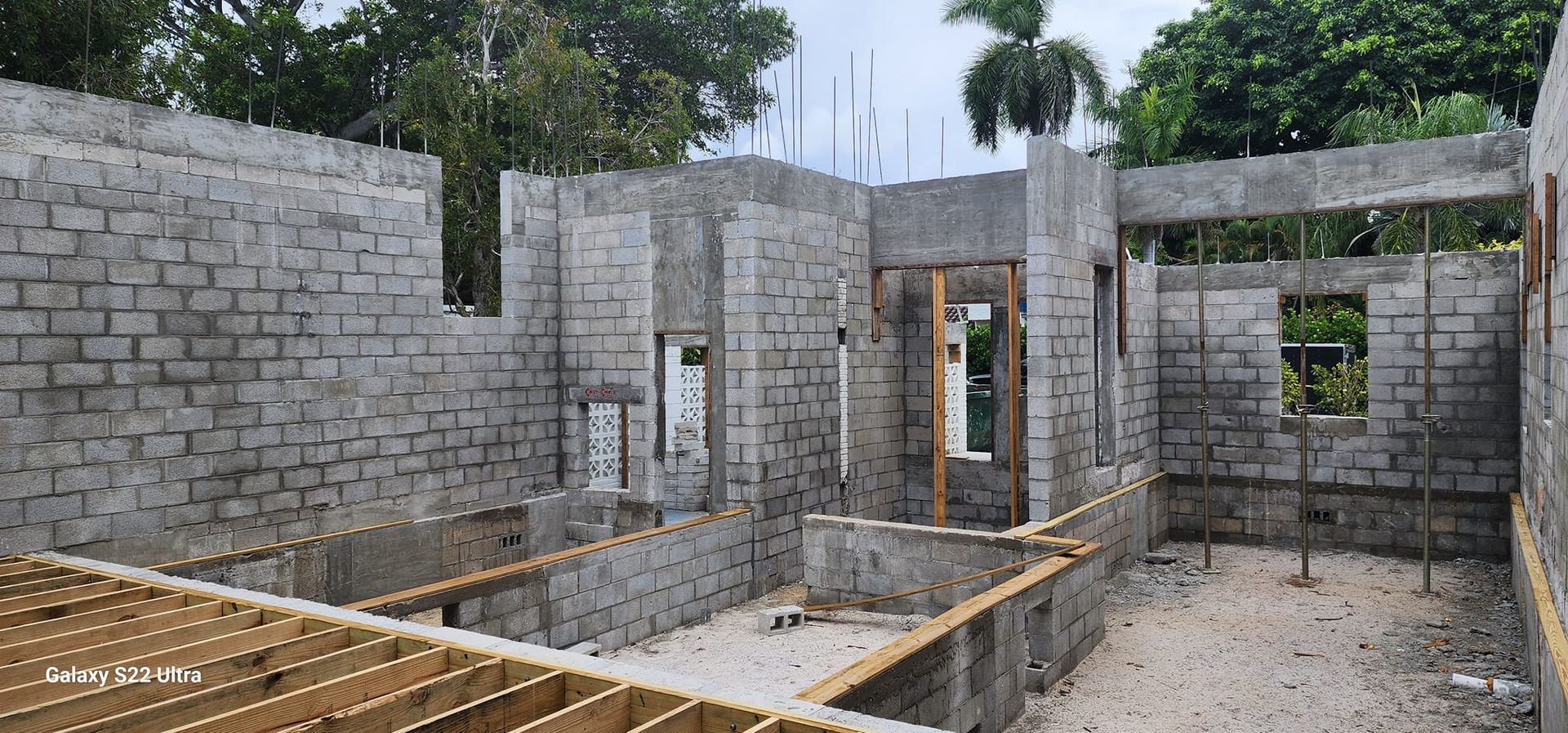 A house is being built with bricks and wooden beams.