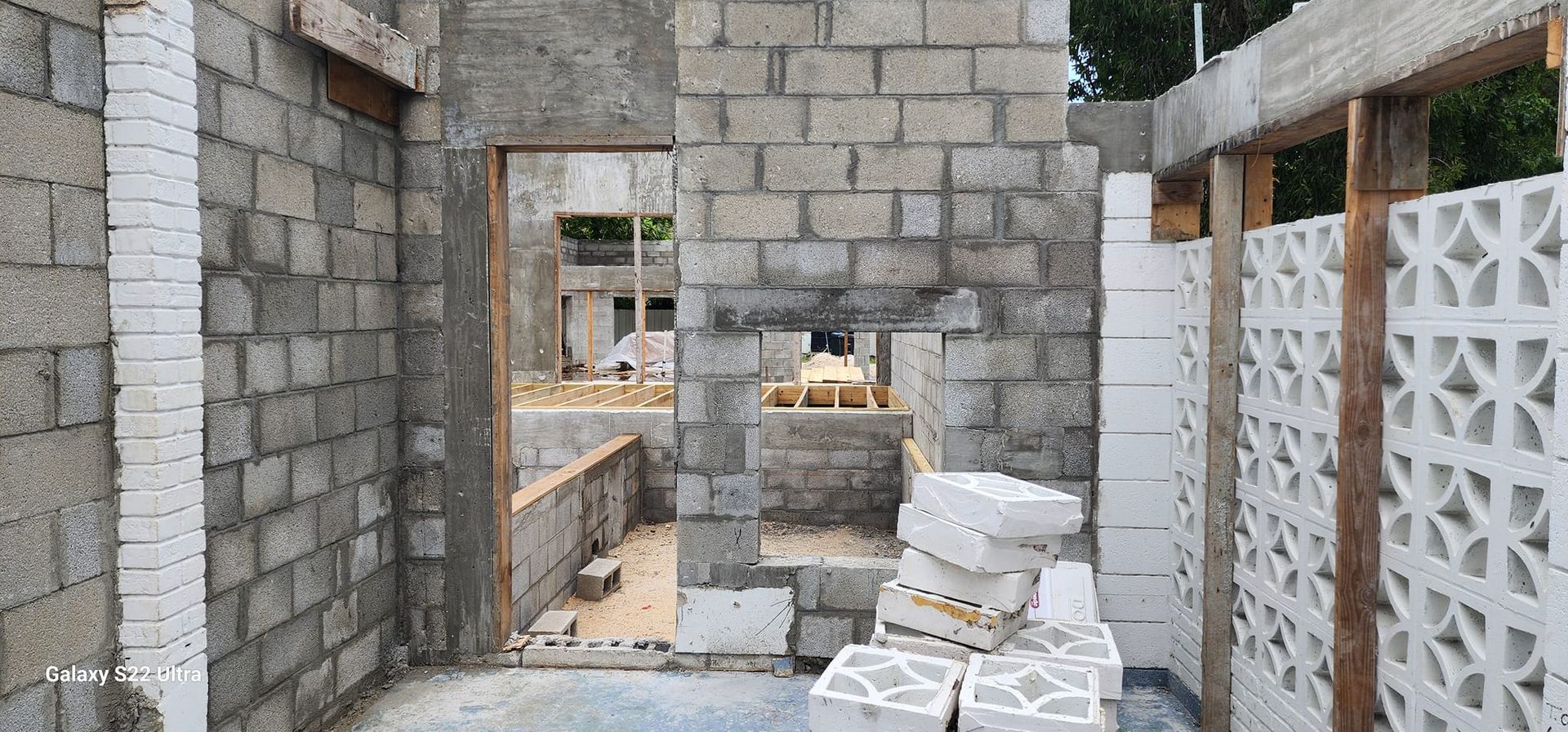 A brick wall with a door in it is being built.