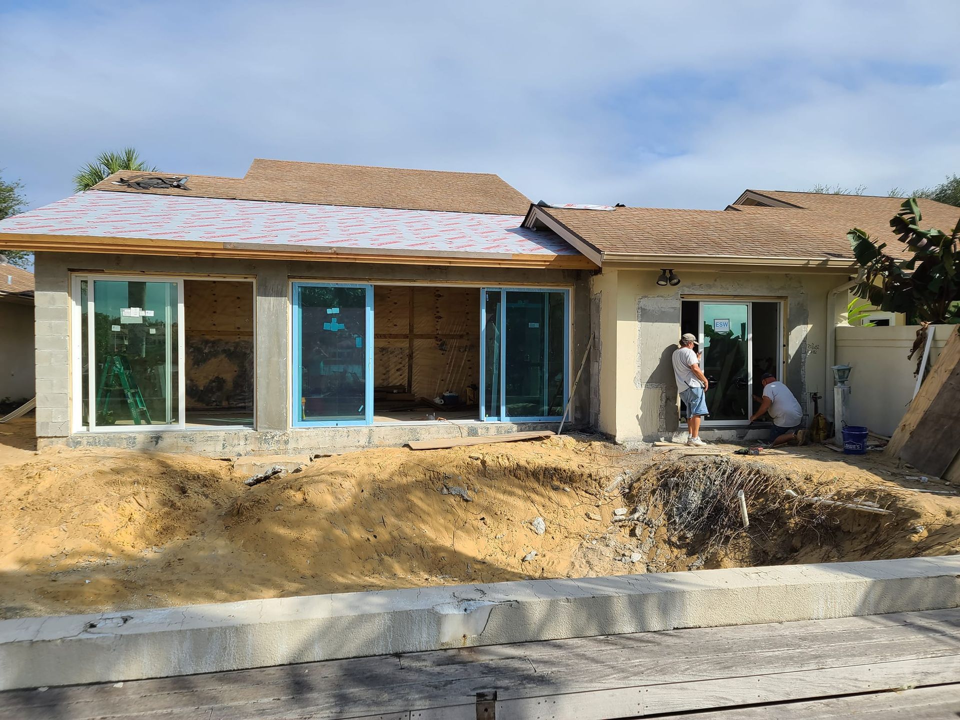 A man is standing in front of a house under construction.