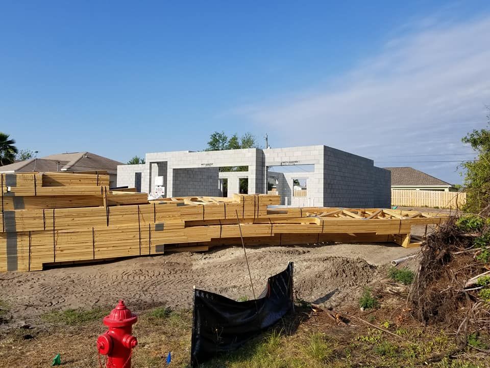 A fire hydrant is in front of a house under construction.