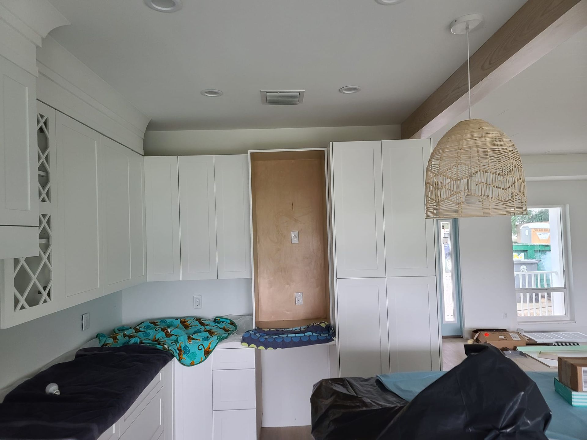 A kitchen with white cabinets and black counter tops is being remodeled.