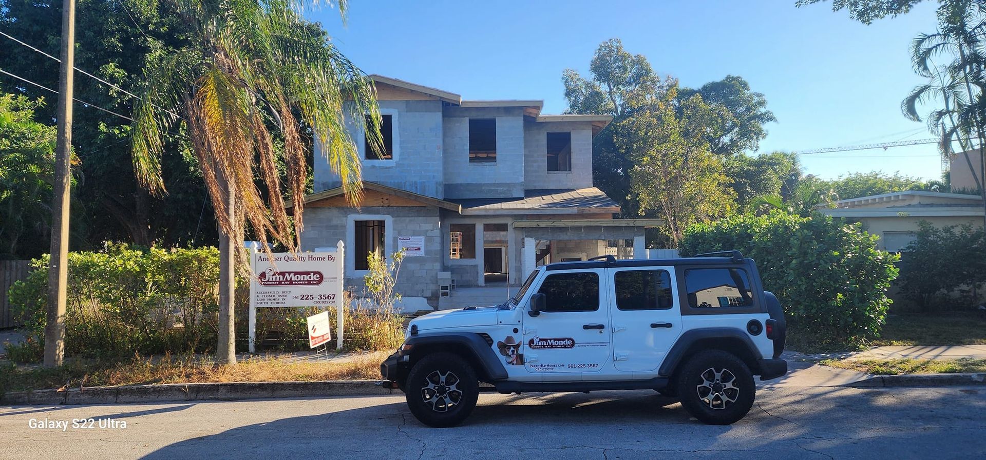 A white jeep is parked in front of a house.